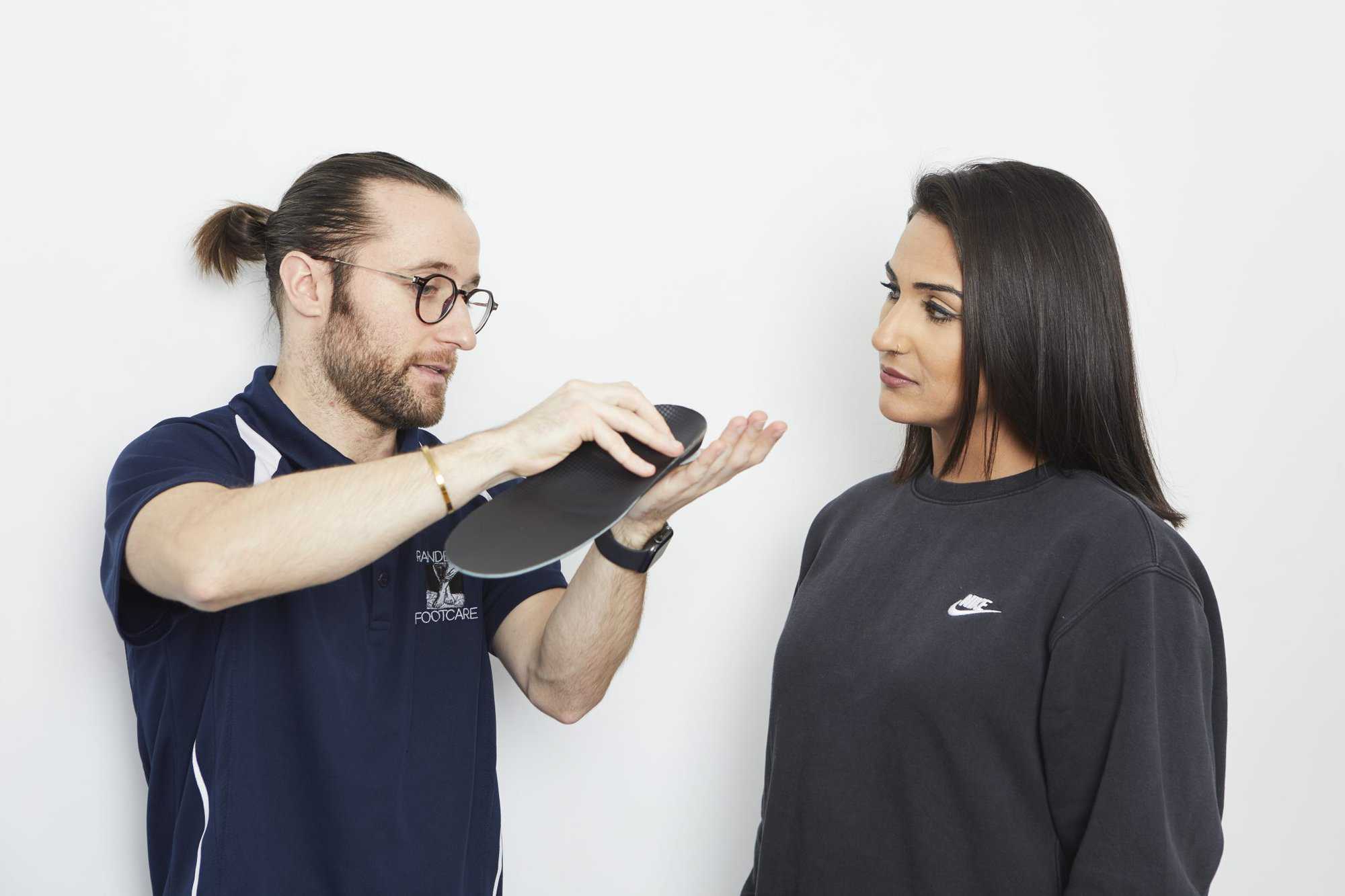 podiatrist explaining orthotic to patient