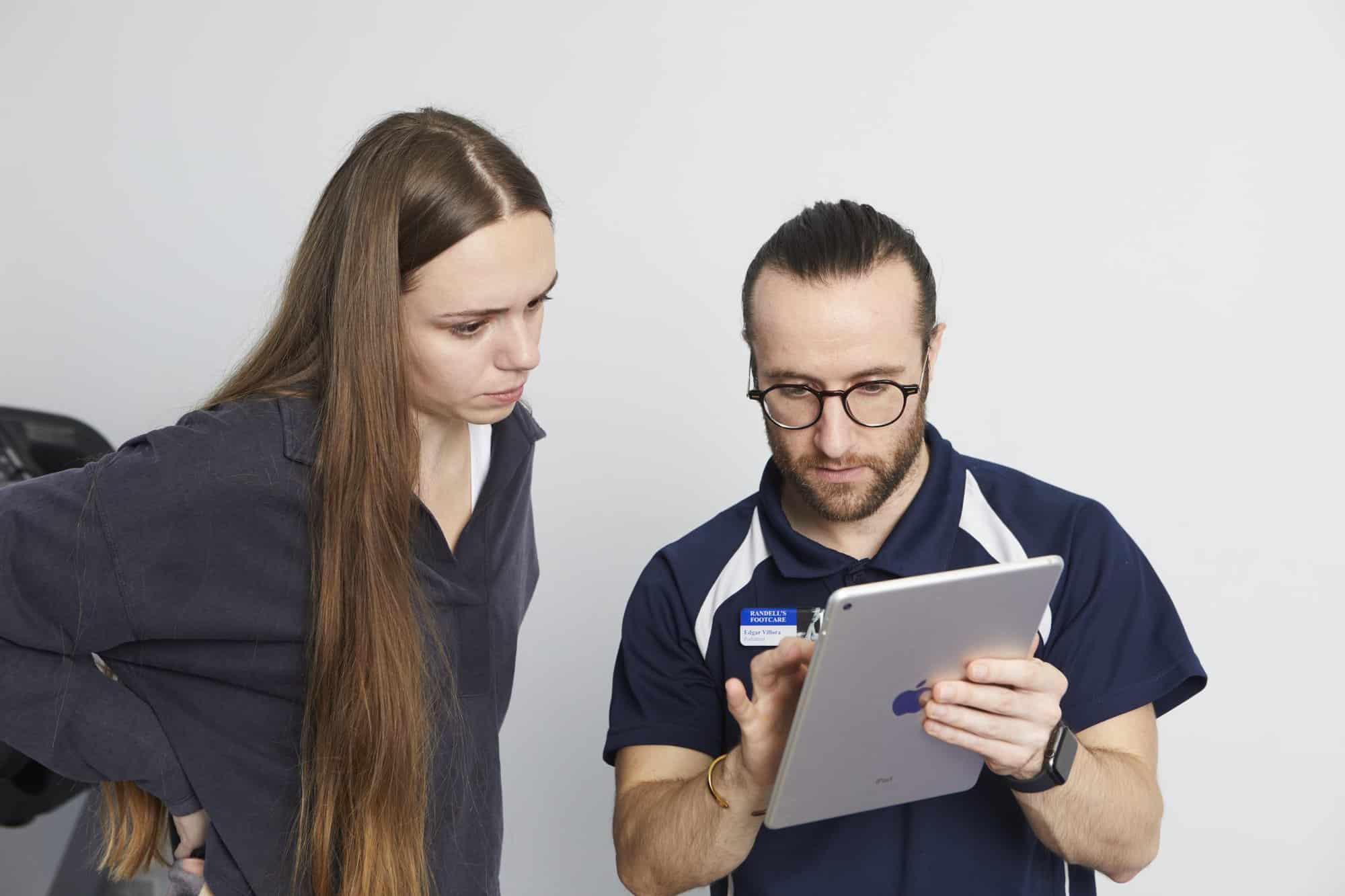 Podiatrist explaining to patient with Ipad